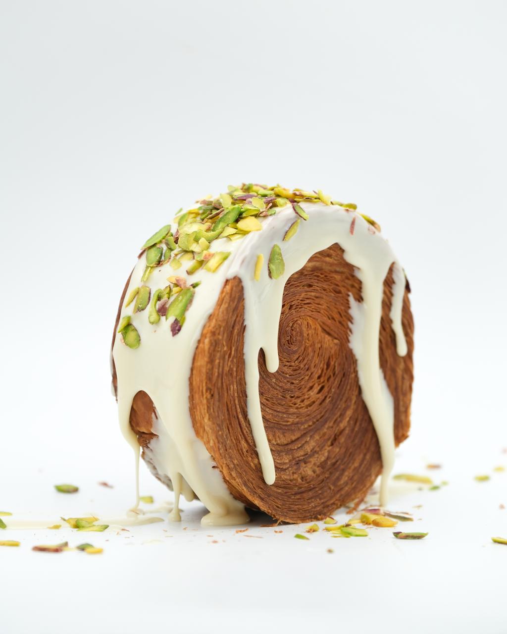 Beyaz kaplamalı, üzeri fıstık parçalı roll kruvasan
